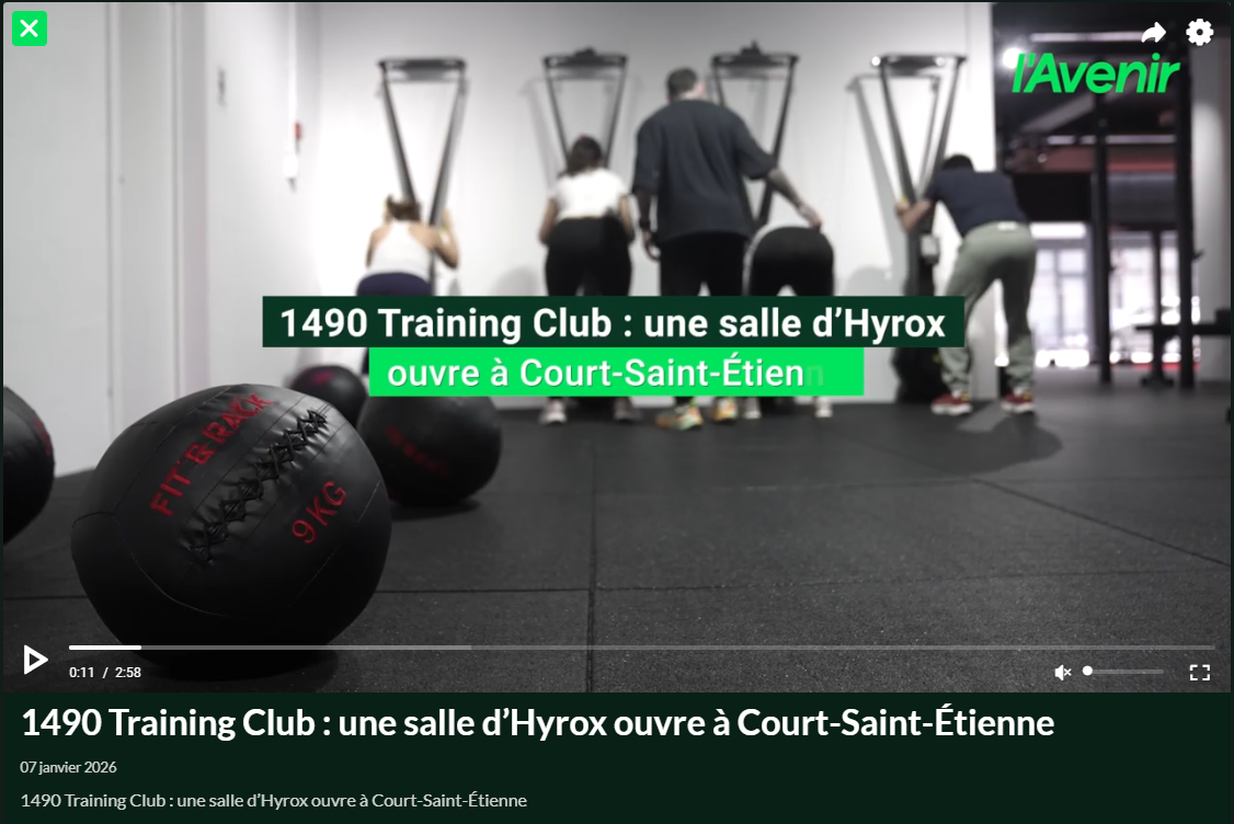 Séance d’entraînement Hyrox au 1490 Training Club avec plusieurs participants sur des machines de cardio, médecine-ball au premier plan.
