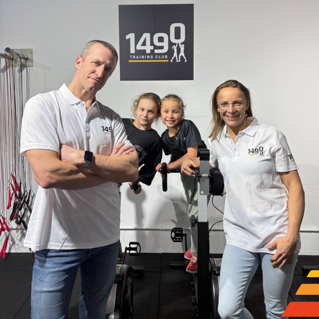 Portrait de Caroline et Xavier, fondateurs du 1490 Training Club, entourés de leurs deux filles, sur fond graphique aux couleurs du club.